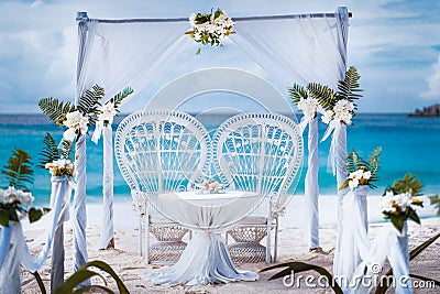Beach wedding arch gazebo ceremonial decorated with white flowers on a tropical grand anse sand beach. Outdoor beach Stock Photo