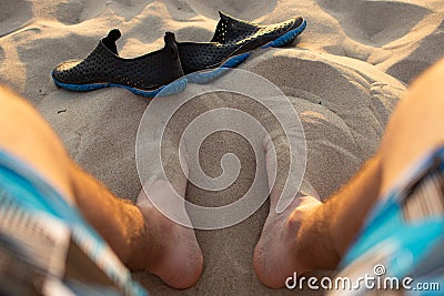 Beachside Reflections: Sunset Sands and Relaxed Legs Stock Photo