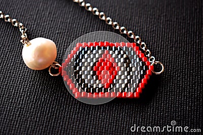 Geometric beaded necklace with pearl on a black surface Stock Photo