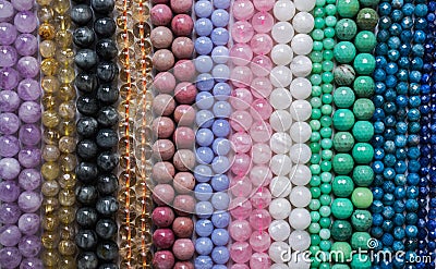 Beads from various types of natural stones are strung on a thread Stock Photo