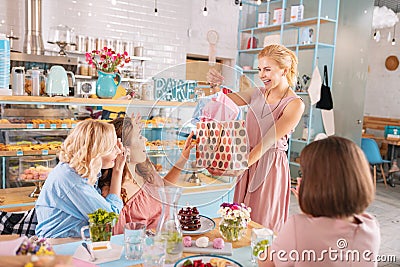 Beaming blonde-haired guest making presents attending baby shower Stock Photo