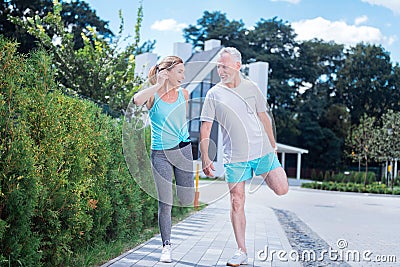 Beaming blonde-haired woman listening to music in earphones after running Stock Photo