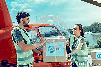 Beaming good-looking woman in clear glasses and her positive bearded workmate Stock Photo