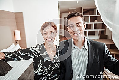 Beaming husband and wife looking into window enjoying view Stock Photo
