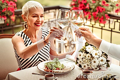 Beaming mature woman drinking wine with husband in the evening Stock Photo