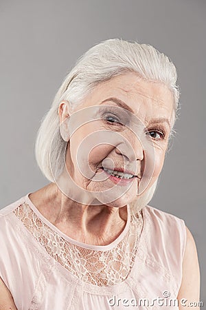 Beaming old woman with short hair working as model in studio Stock Photo