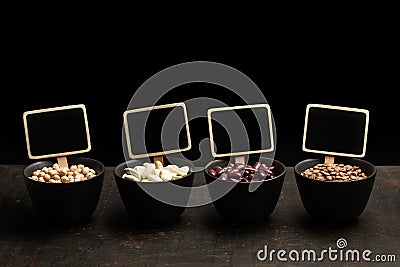 Beans, lentils and chickpeas in black bowls Stock Photo
