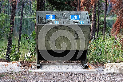 A bear proof garbage container along side a parking lot Stock Photo