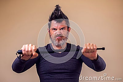 Bearded angry man with tonfa. People, emotions concept Stock Photo