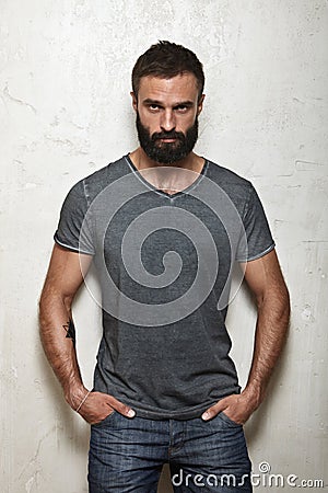 Bearded brutal guy wearing blank grey t-shirt Stock Photo