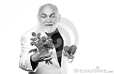 Bearded businessman. heart failure. happy mature man hold flowers and heart. love and romance. anniversary and Stock Photo