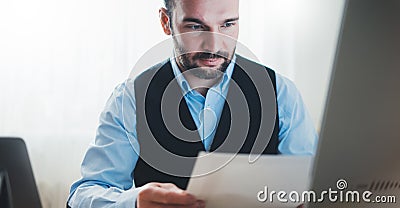 Bearded businessman looking document background monitor computer, man working at social distance at home workplace, freelancer Stock Photo