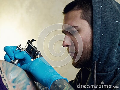 Bearded Caucasian tattooist Stock Photo