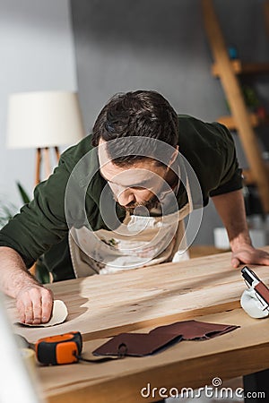Bearded craftsman sanding surface of wooden Stock Photo