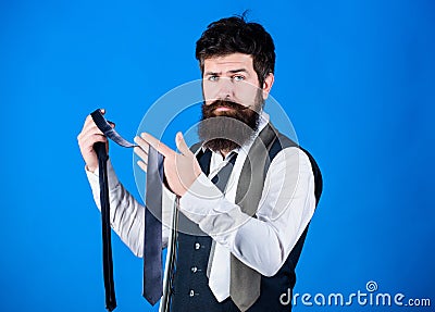 Bearded but elegant. Long bearded hipster choosing neckwear. Bearded man holding necktie. Cheerful man with unshaven Stock Photo