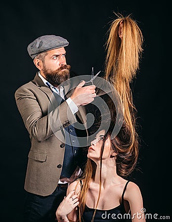 Long hair hairstyle concept. Bearded Hairdresser making hair styling and cut. Hairdressers work. Barber scissors. Stock Photo