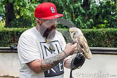 Bearded hipster with an owl in his hand Editorial Stock Photo