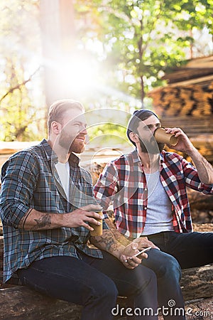 bearded lumberjacks with smartphone drinking coffee from papers cups Stock Photo