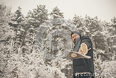 Bearded man with axe in snowy forest. Stock Photo