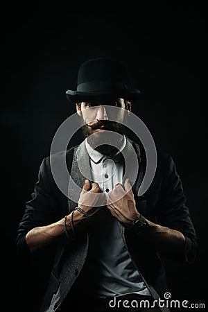 The bearded man in a bowler hat holding his lapels Stock Photo