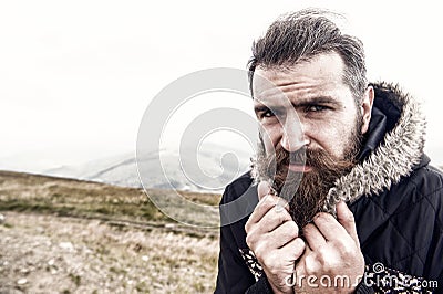 Bearded man, brutal caucasian hipster with moustache cold on mountain Stock Photo