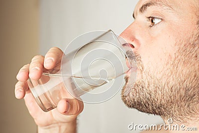 Bearded man drinks water from a glass Stock Photo