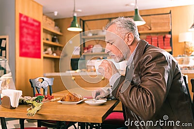 Bearded man feeling amazing smelling cup of fresh coffee Stock Photo