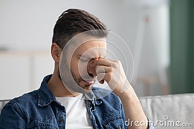 Bearded man having headache, touching his nose bridge Stock Photo