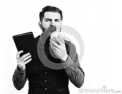 Bearded man holding notepad and moneybox with serious face Stock Photo