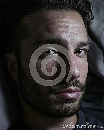 Bearded man laying down on bed. Stock Photo