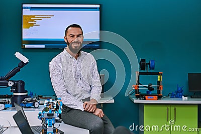 A bearded man in a modern robotics laboratory, immersed in research and surrounded by advanced technology and equipment Stock Photo