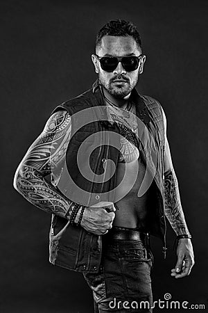 Bearded man with tattoo on chest and arms. Fashion macho in trendy sunglasses. Tattoo model with beard on unshaven face Stock Photo