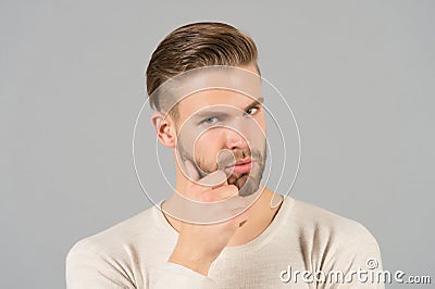 Bearded man touch beard with hand. Macho with stylish hair and healthy young skin. Guy with unshaven face and mustache. Beard groo Stock Photo