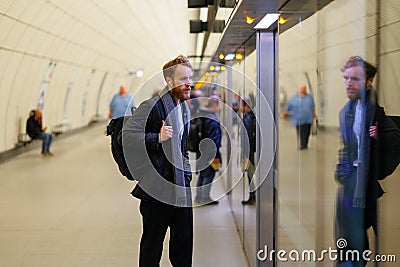 Bearded man waits for the door to open on the subway station platform. Stock Photo