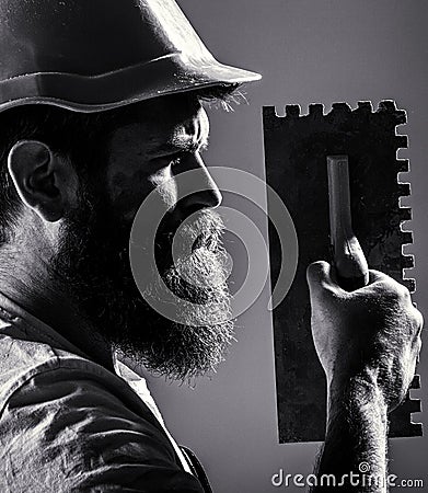 Bearded man worker, beard, building helmet, hard hat. Plastering tools. Tool, trowel, handyman, man builder. Mason tools Stock Photo