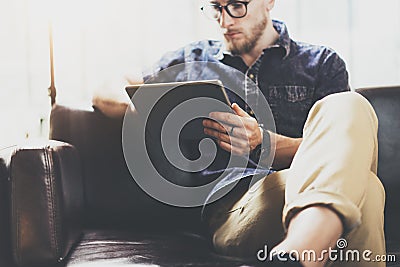 Bearded marketing specialist working digital tablet modern Interior Design Loft Office.Man relax classic sofa use Stock Photo