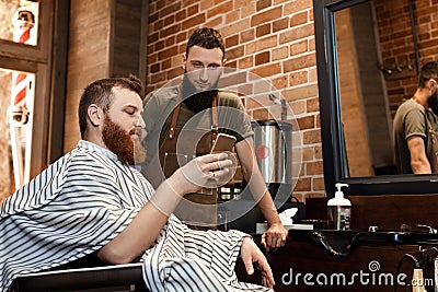Barber and bearded man in barber shop Stock Photo