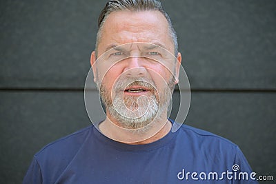 Bearded middle aged man staring at camera in consternation Stock Photo