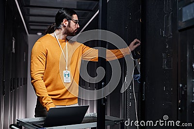 Bearded network engineer using laptop while working in server room Stock Photo