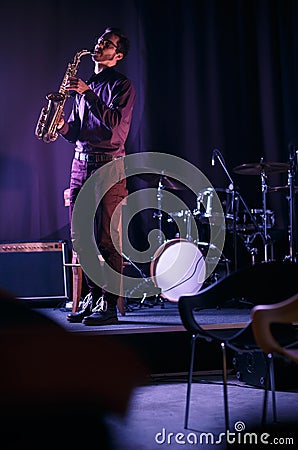 Bearded saxophonist alone on stage Stock Photo