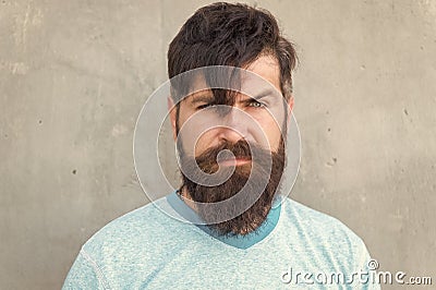 Bearded and shaggy. Bearded man with stylish haircut on grey wall. Unshaven caucasian guy wearing thick mustache and Stock Photo