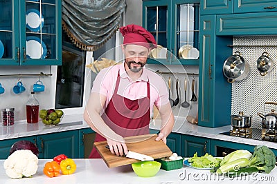 Bearded smiling Chef makes salad in kitchen Stock Photo