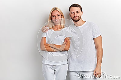Bearded smiling handsome man hugs a woman by the shoulder on a white background Stock Photo