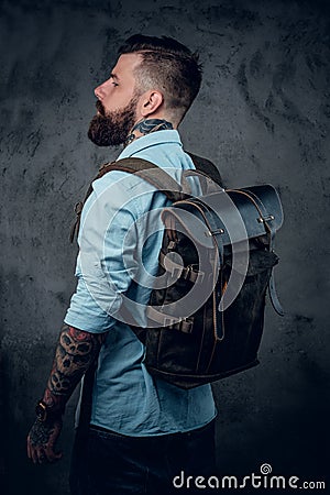 Bearded tattooed backpacker posing in studio. Stock Photo