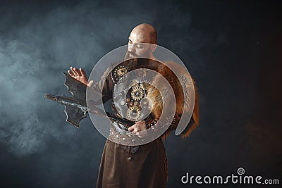 Bearded viking touches the axe blade Stock Photo