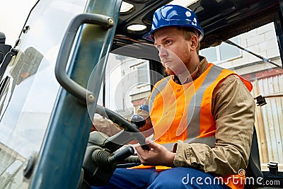 Bearded worker driving lift truck Stock Photo