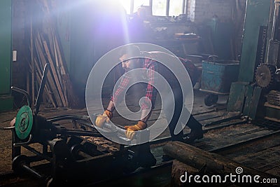 bearded worker in protective gloves pushing machine Stock Photo