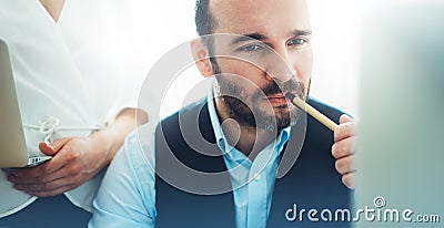 Bearded young businessman working on modern office. Consultant man thinking looking in monitor computer. Manager coworking on work Stock Photo