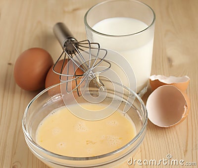 Beat eggs with milk in a glass bow Stock Photo