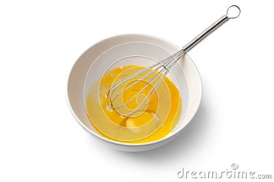 Beaten egg yolks in a bowl with whisk Stock Photo